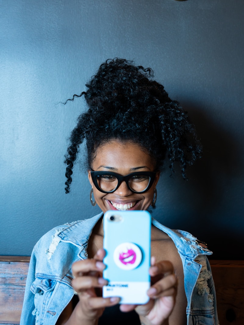 Smiling woman holding her smartphone